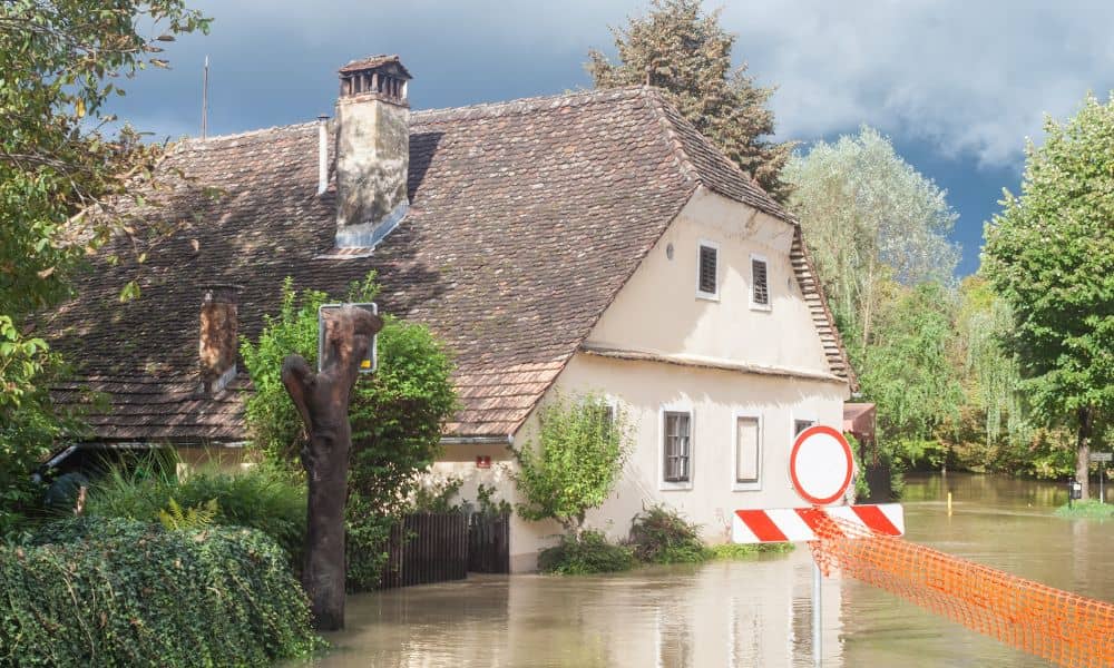 Flooded residential home with standing water highlighting the need for a boundary line survey before property repairs