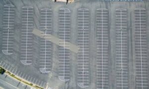 Commercial parking lot with marked stalls and drive aisles, illustrating the site layout considered in topographic survey work for EV charging