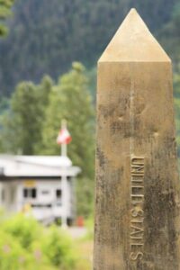 A stone boundary marker stands upright in an outdoor setting, used to indicate property corners during a land survey.