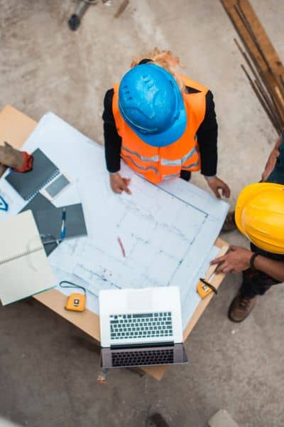 Engineers reviewing survey blueprints laptop - ALTA SURVEY Nevada Engineers reviewing ALTA Land Title Survey plans and elevation data to assess property accuracy after an earthquake