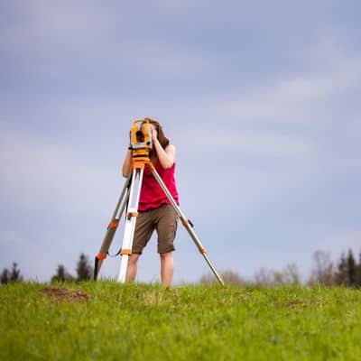 Land surveyor measuring property boundaries during a boundary line survey