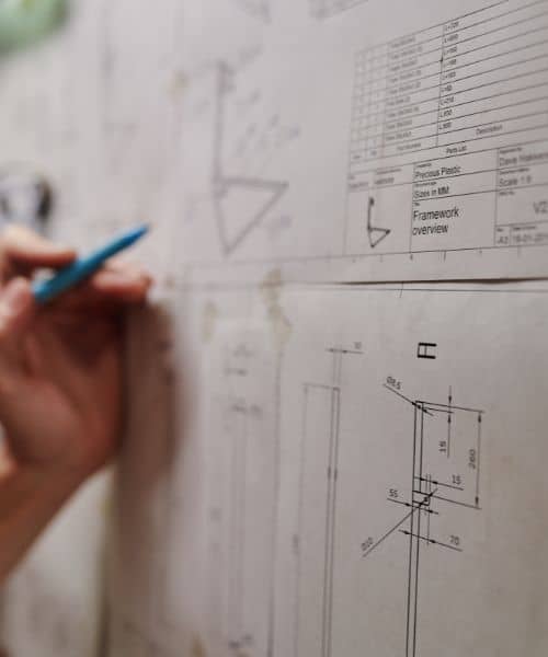 A surveyor reviewing technical drawings and measurement notes as part of updated survey standards