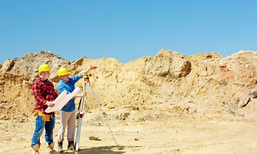 Surveyors conducting an ALTA land title survey on an undeveloped site during early due diligence