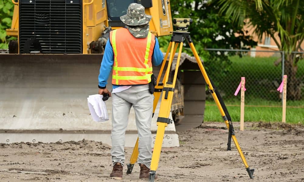 Professional land surveyor marking property boundaries using precision equipment on a construction site