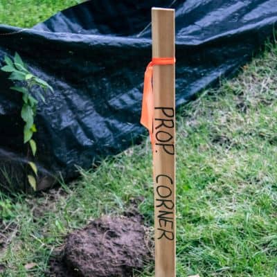 Wooden corner stake marking a residential property line survey before construction begins
