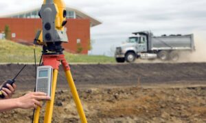 Surveyor from a land survey company measuring a property boundary with a total station