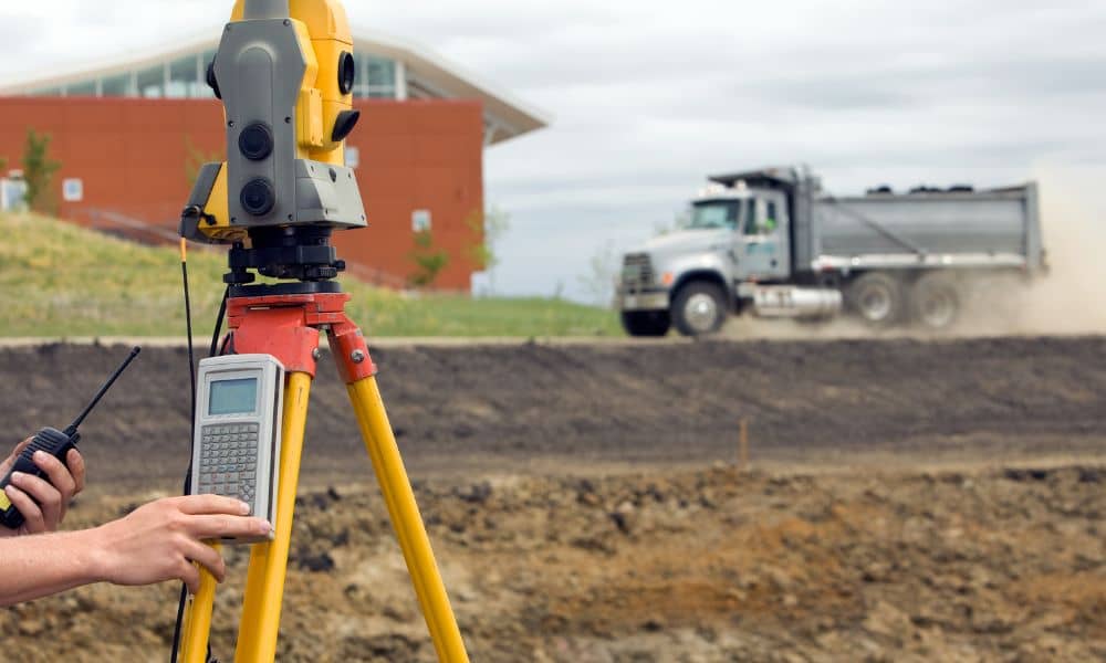 Surveyor from a land survey company measuring a property boundary with a total station