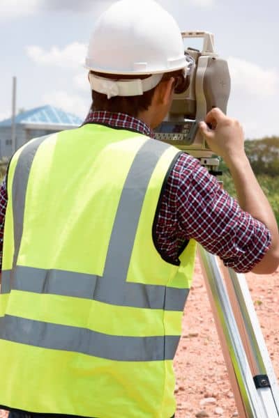 Land surveyor measuring property boundaries on site - ALTA SURVEY Nevada Land surveyor using equipment on-site to measure property boundaries and confirm details from a property survey