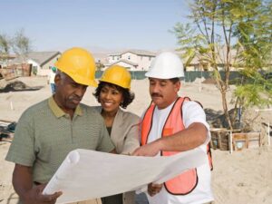 Licensed land surveyor reviewing property plans with a buyer and construction professional in Las Vegas