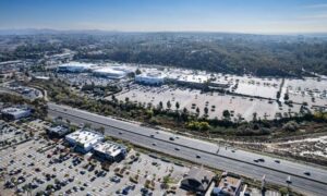 Aerial view of a commercial property with drive aisles, parking, and nearby highway access, illustrating site conditions documented in an ALTA land survey for a ground lease